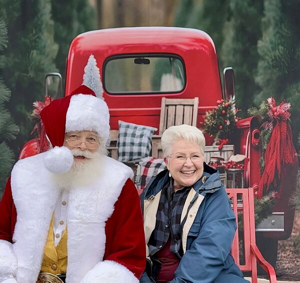 Santa Ray with a smiling guest in front of a red vintage truck