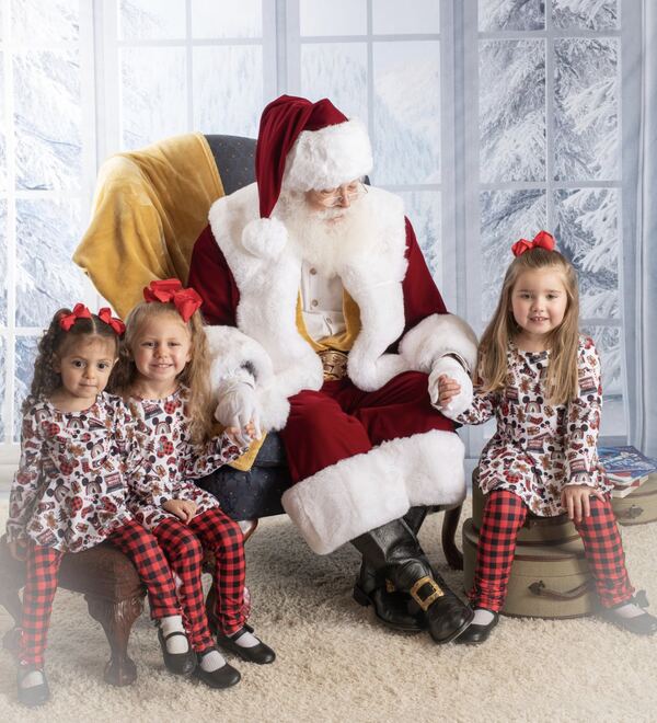 Santa Ray seated with three little girls by a snowy window