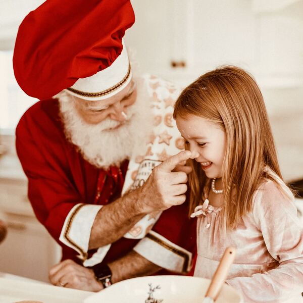 A girl whispering her wish to Santa Ray