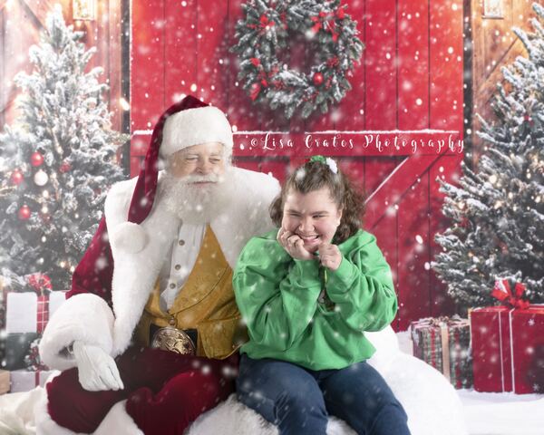 Santa Ray with a laughing boy in a green sweater