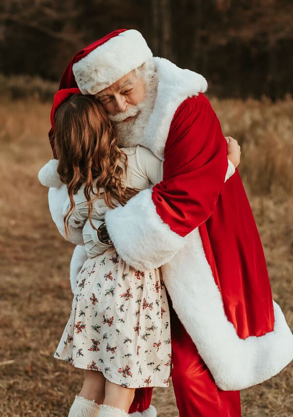 A girl hugging Santa Ray in a meadow