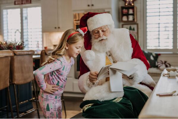 Santa Ray with a girl in pajamas at the kitchen island