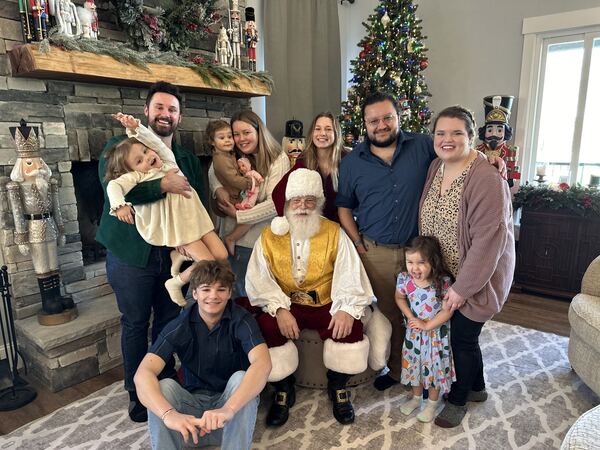 Santa Ray with a family gathered in their living room